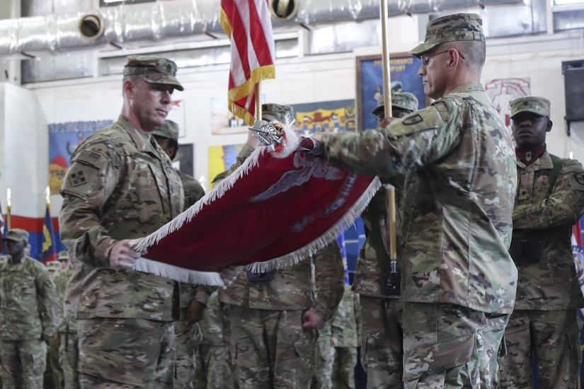 Col. Bruce Syvinski (right), the commander of the 86th Combat Support Hospital, and Command Sgt. Maj. Daryl Forsythe, the command sergeant major for the 86th CSH, uncases the unit’s colors, during the transfer of authority ceremony, in the Zone 1 Fitness Center, Camp Arifjan, Kuwait, May 5. The ceremony marked the last deployment for the 86th CSH, as it will re-designate into a field hospital when it returns from this rotation. (U.S. Army photo by Sgt. Bethany Huff, ARCENT Public Affairs)