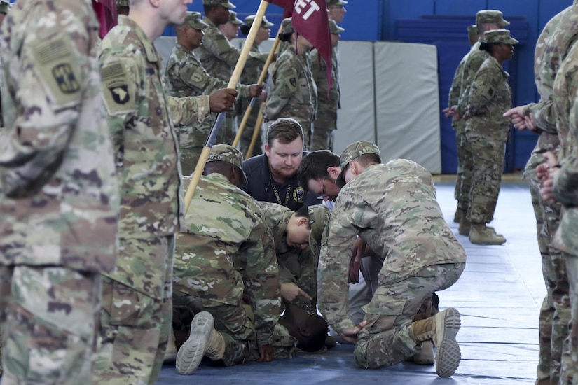 Phantom medics of the 31st Combat Support Hospital, do what they do best by immediately providing medical attention to a Solider who passed out during the transfer of authority ceremony, in the zone one gym, at Camp Arifjan, May 5. Col. George Kyle, the commander of the 31st CSH, stated that his Soldiers are always ready, whether that be for the Soldiers in the battlefield, or their own. The Soldier was rendered aid immediately, and is doing well. (U.S. Army photo by Sgt. Bethany Huff, ARCENT Public Affairs)