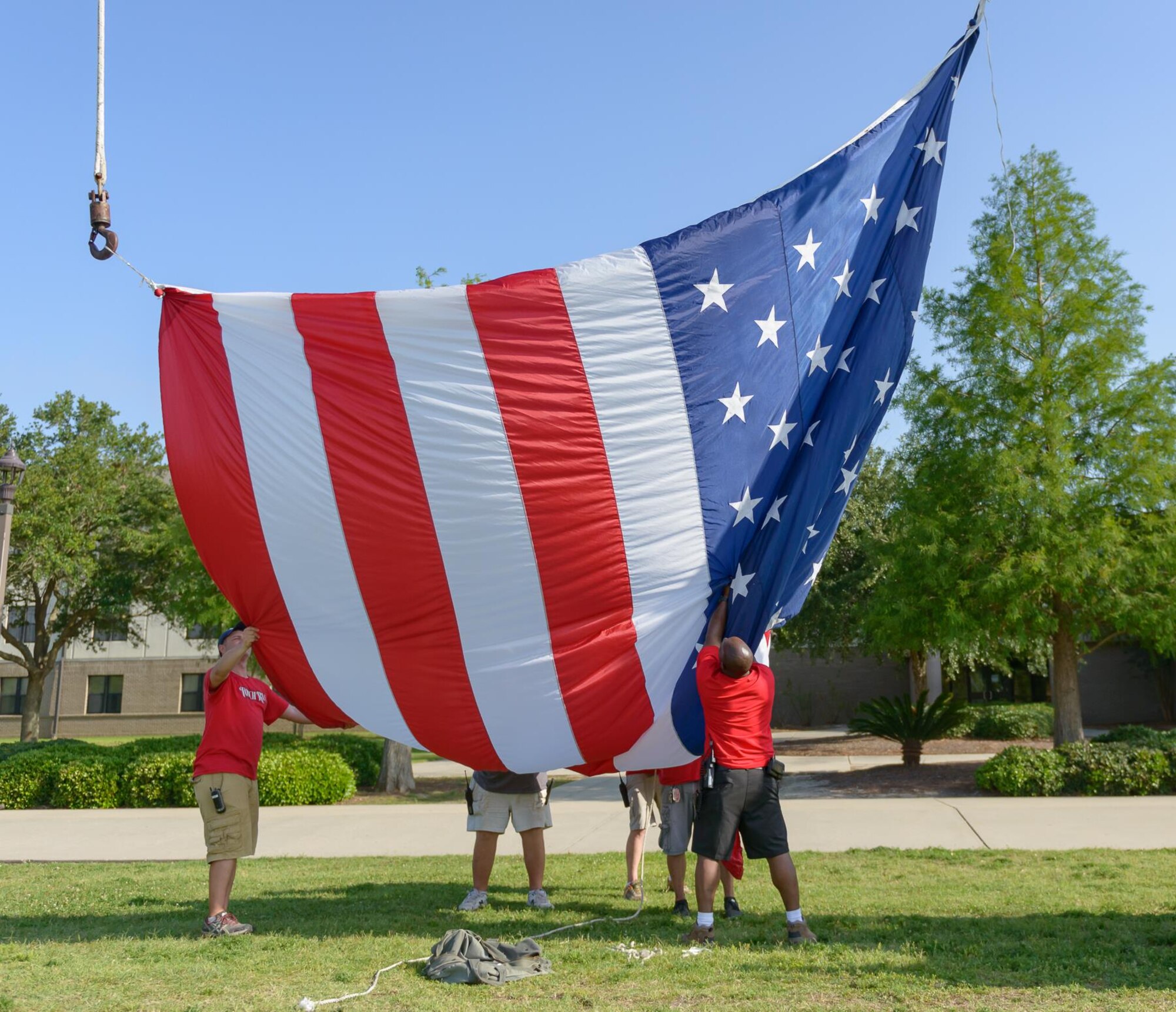 Keesler volunteers lift an U.S. flag during the Special Olympics Mississippi 2017 Summer Games opening ceremonies at the Levitow Training Support Facility drill pad May 19, 2017, on Keesler Air Force Base, Miss. Founded in 1968, Special Olympics hosts sporting events around the world for people of all ages with special needs to include more than 700 athletes from Mississippi. (U.S. Air Force photo by Andre’ Askew)