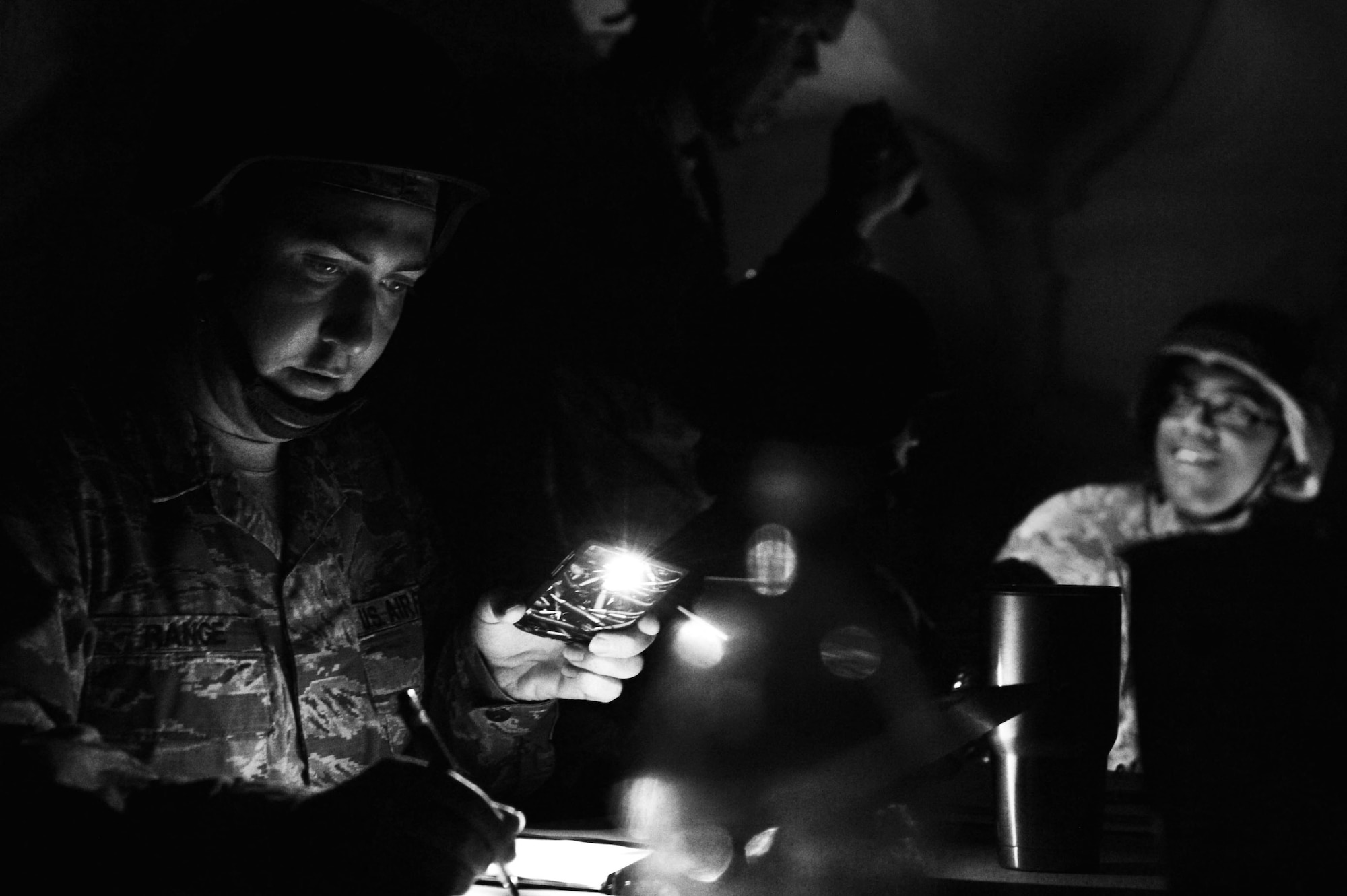 U.S. Air Force Staff Sgt. Matthew Range, 20th Civil Engineer Squadron electrical systems journeyman, uses his phone to shine light on paperwork following a simulated power outage during operational readiness exercise Weasel Victory 17-07 at Poinsett Electronic Combat Range near Wedgefield, S.C., May 16, 2017. Airmen were required to adapt to changing condition in order to complete the mission. (U.S. Air Force photo by Airman 1st Class Christopher Maldonado)