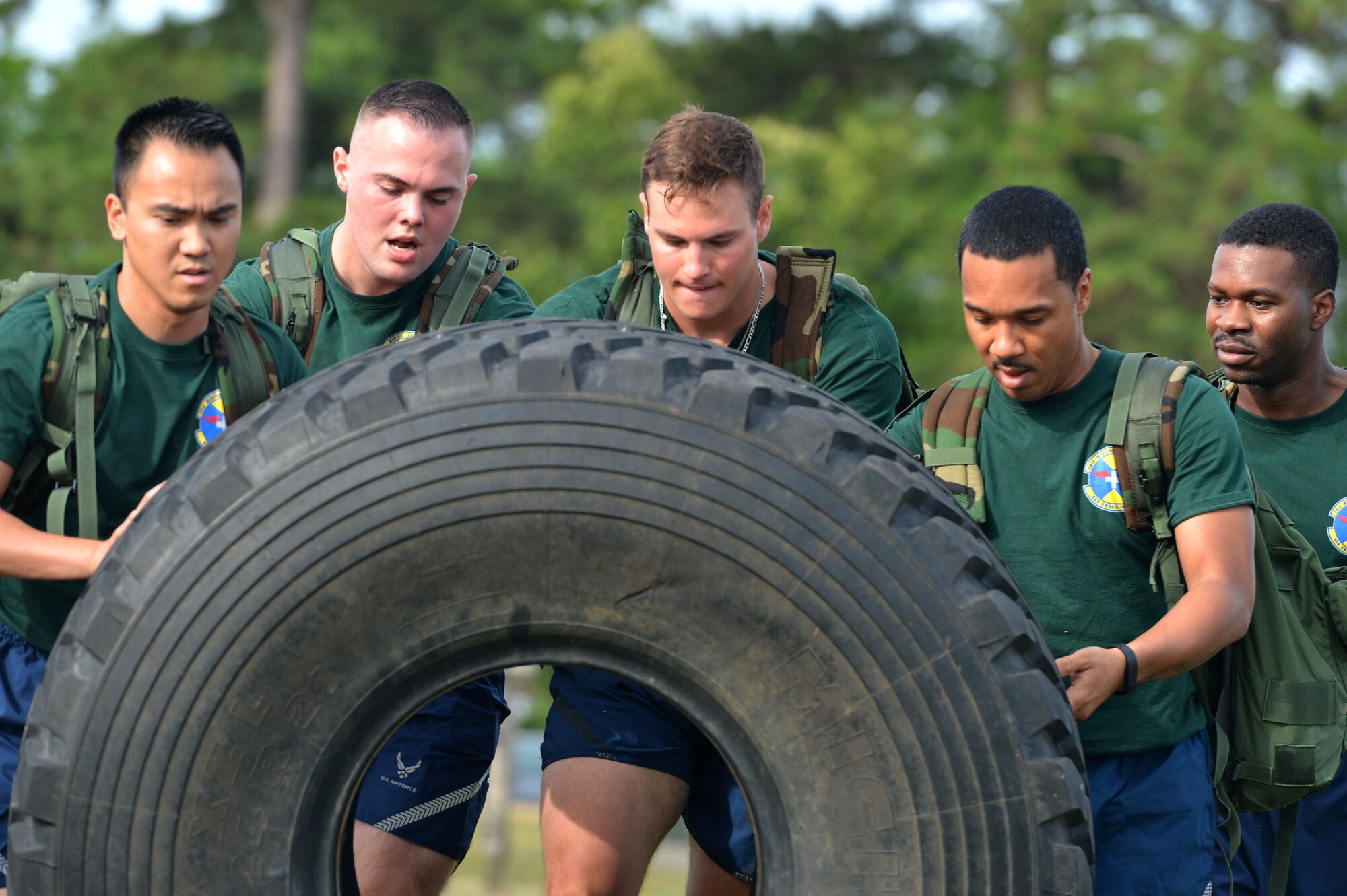 U.S. Airmen assigned to the 20th Medical Support Squadron flip a tire during the 20th Operations Group-hosted warrior day challenge at Shaw Air Force Base, S.C., May 19, 2017. The tire flip provided Airmen the opportunity to test their physical resiliency with increased weight provided by a rucksack. (U.S. Air Force photo by Airman 1st Class Christopher Maldonado)
