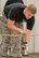 U.S. Air Force Senior Airman Wesley Hemer, aircraft service element member, 19th Logistics Readiness Squadron, hangs one of five MB-1 Tie-down Devices to a chain May 19, 2017, at Little Rock Air Force Base, Ark. The devices were inscribed with the names of “Port Dawg” members from across the Air Force, who lost their lives during 2016. (U.S. Air Force photo by Master Sgt. Jeff Walston/Released)