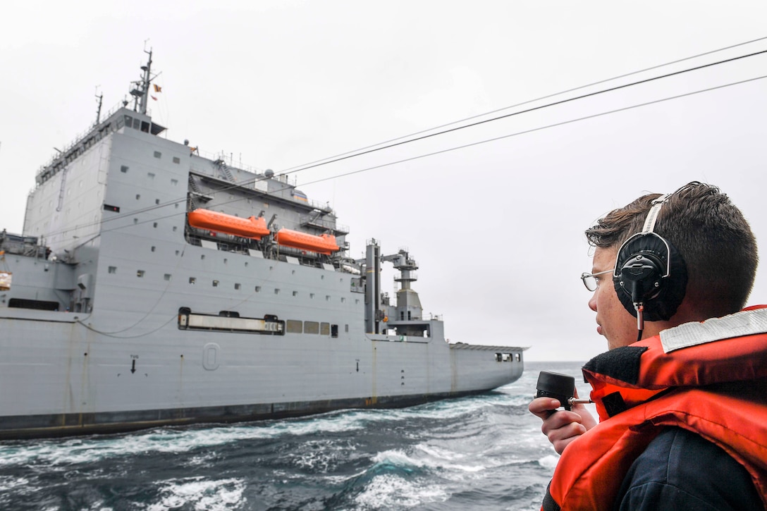 Navy Seaman Alexander Henley talks on the phone as the Arleigh Burke-class guided missile destroyer USS Wayne E. Meyer receives cargo from Lewis and Clark-class dry cargo ship USNS Wally Schirra during a replenishment-at-sea in the western Pacific Ocean, May 13, 2017. Henley is a cryptologic technician (technical). Navy photo by Petty Officer 3rd Class Kelsey L. Adams 