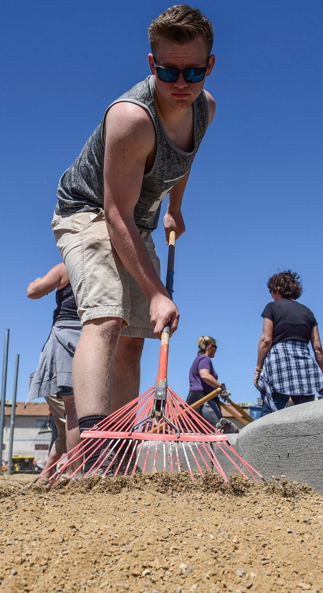 Airman Logan Gaines, 99th Medical Group mental health technician, rakes dirt around a newly built garden between J.E. Manch and Zel & Mary elementary schools, May 12, 2017. Students at the elementary schools will be able to grow fruits and vegetables as part of their outdoor curriculum. Anyone can purchase the fruits and vegetables from the garden and the money collected goes back to the school for seeds, fertilizer and other outdoor projects. (U.S. Air Force photo by Airman 1st Class Andrew D. Sarver/Released)