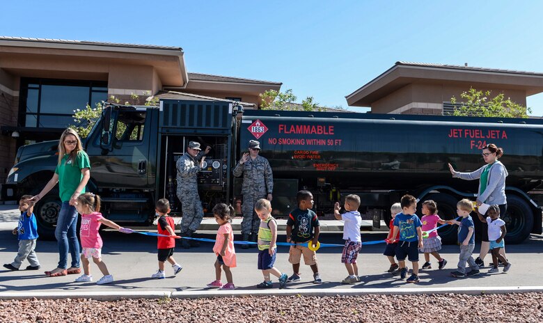 Children wave to Airmen assigned to the 99th Logistics Readiness Squadron standing in front of an R-11 Refueler truck at Nellis Air Force Base, Nev., May 16, 2017. The truck is capable of storing nearly 6,000 gallons of fuel. (U.S. Air Force photo by Airman 1st Class Andrew D. Sarver/Released)