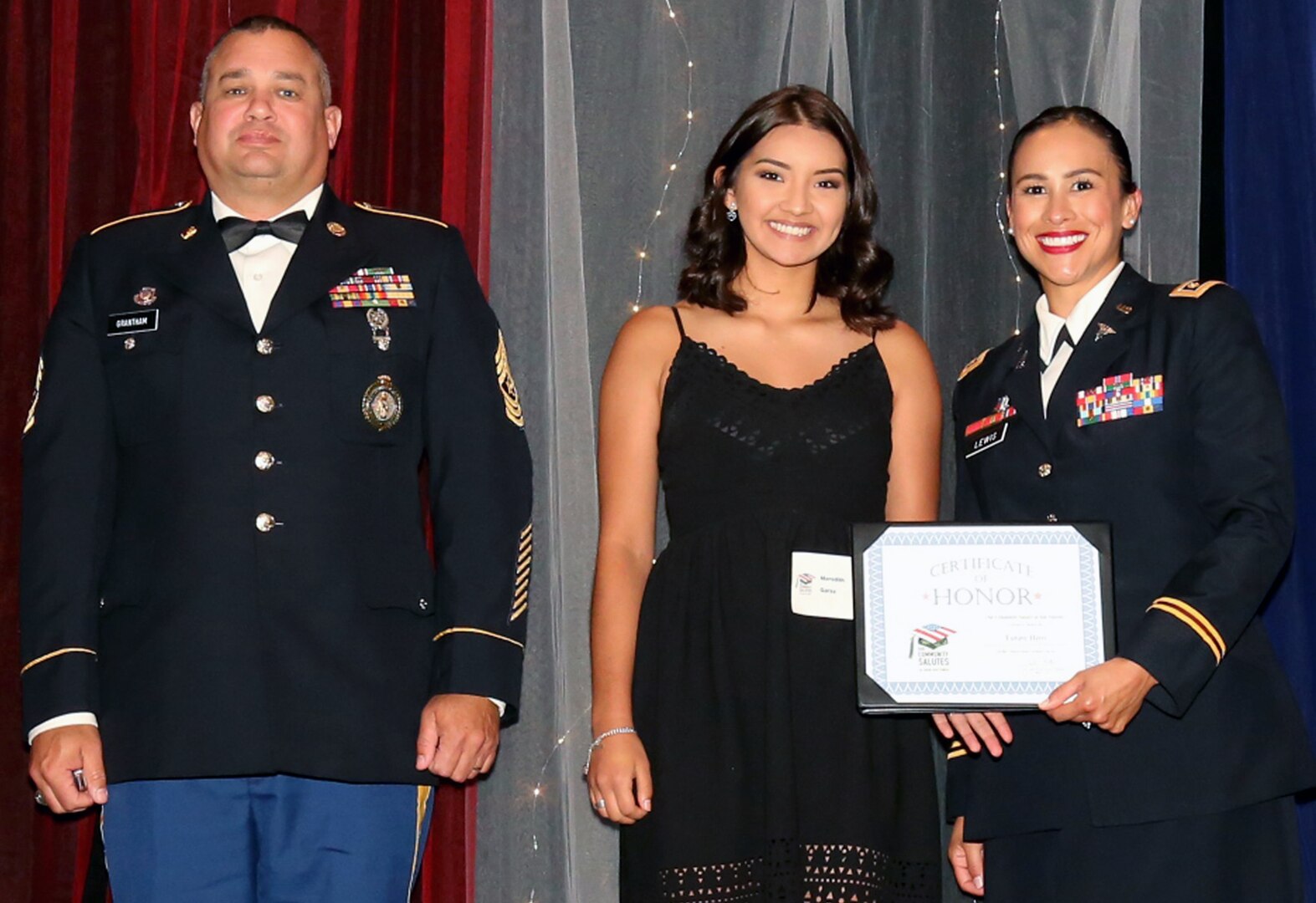 Texas Army National Guard Capt. Samantha Lewis and Sgt. Maj. Richard Grantham pose with Meredith Garza, a future Guardsman, who was honored during Our Community Salutes-San Antonio’s 6th Annual “A Night in Your Honor” held in the Rosenberg Sky Room at the University of the Incarnate Word.  Each honoree received an Our Community Salutes certificate and challenge coin from USAA.