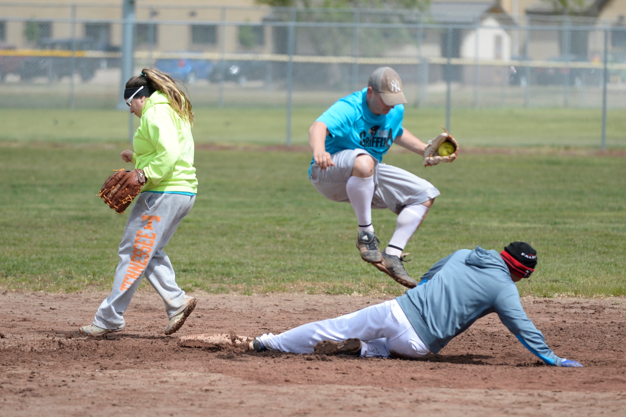 Staff Sgt. Kenneth Barthold, 367th Training Support Squadron, fields a fly ball at second base and goes for the tag on Airman Matthew Vonsavaugh, 388th Operations Support Squadron, during a tournament softball game May 16 at Hill Air Force Base, Utah. Also, pictured is Moriah Barthold. The Defenders Challenge Softball Tournament was organized by 75th Security Forces Airmen as one of several events celebrating National Police Week. (Air Force photo/Todd Cromar)