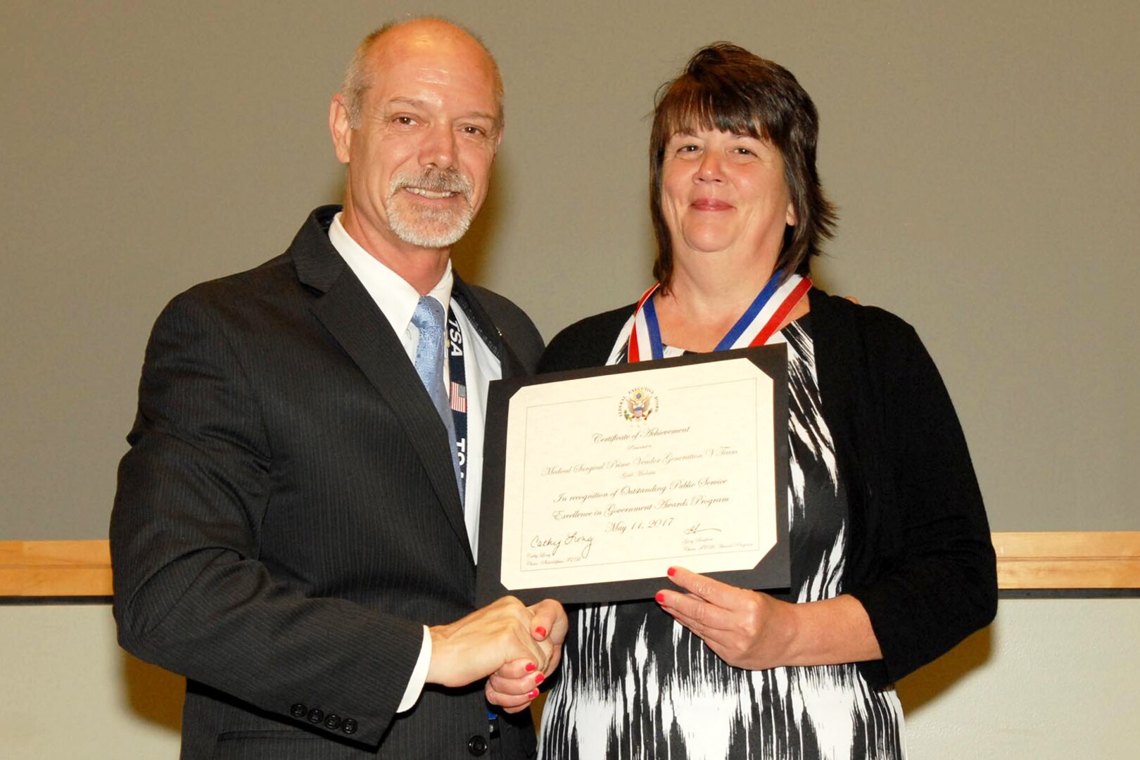 Nancy Martin, Troop Support Medical supply chain, accepted the gold medal on behalf of the Medical Surgical Prime Vendor team for the Economy in Government Operations Achievement award at the Excellence in Government Awards ceremony in Philadelphia May 18. Gary Renfrow (left), a vice chair of the Philadelphia Federal Executive Board, presented the award. Other members of the MSPV team include Steve Bollendorf, Maryann DiMeo, David Zarenkiewicz, Brian Mason, Tara J. Perrien and Gail Viola. Photo by Ed Maldonado.

