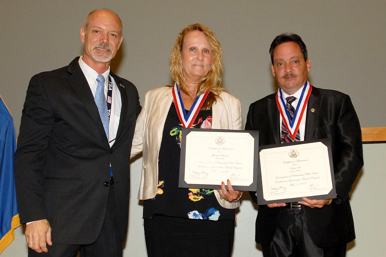 Lorinda Ferraiolo (center), a Troop Support Medical contracting officer, was presented a gold medal for Steadfast Achievement at the Excellence in Government Awards ceremony in Philadelphia May 18. The award recognizes federal employees who have performed at the highest standards for more than 20 years. Gary Renfrow (left), a vice chair of the Philadelphia Federal Executive Board, presented the gold medal to Ferraiolo and a bronze medal to Martin Pio from the Defense Contract Management Agency. Photo by Ed Maldonado.