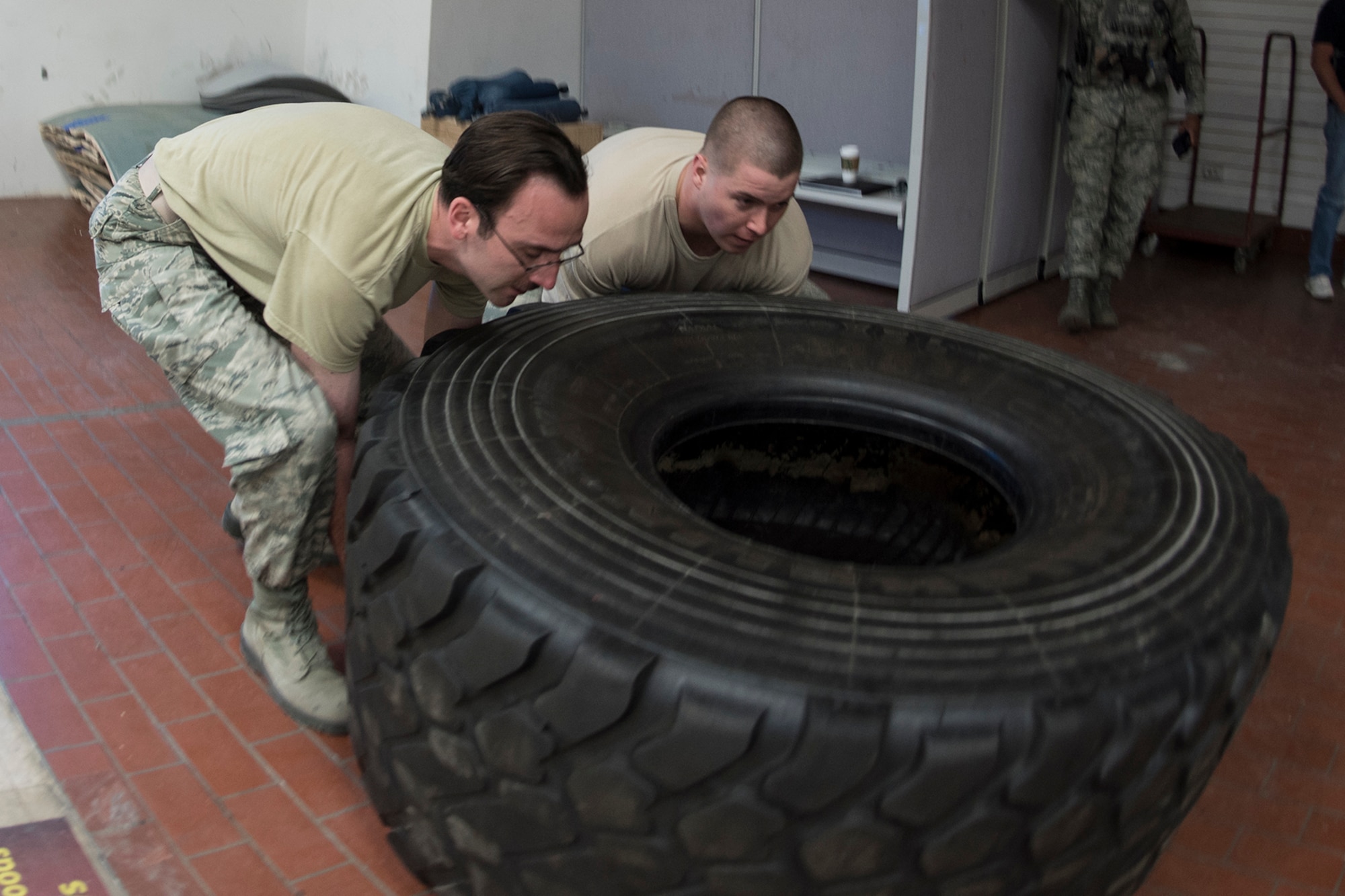 PETERSON AIR FORCE BASE, Colo. – Team Pete Airmen flip a tire during an obstacle course for National Police Week, May 18, 2017 at Peterson Air Force Base, Colo. The obstacle course was one of several events the 21st Security Forces Squadron hosted for Police Week, May 15-19, including a distracted driving simulator, combatives tournament, and BBQ. (U.S. Air Force photo by Steve Kotecki)
