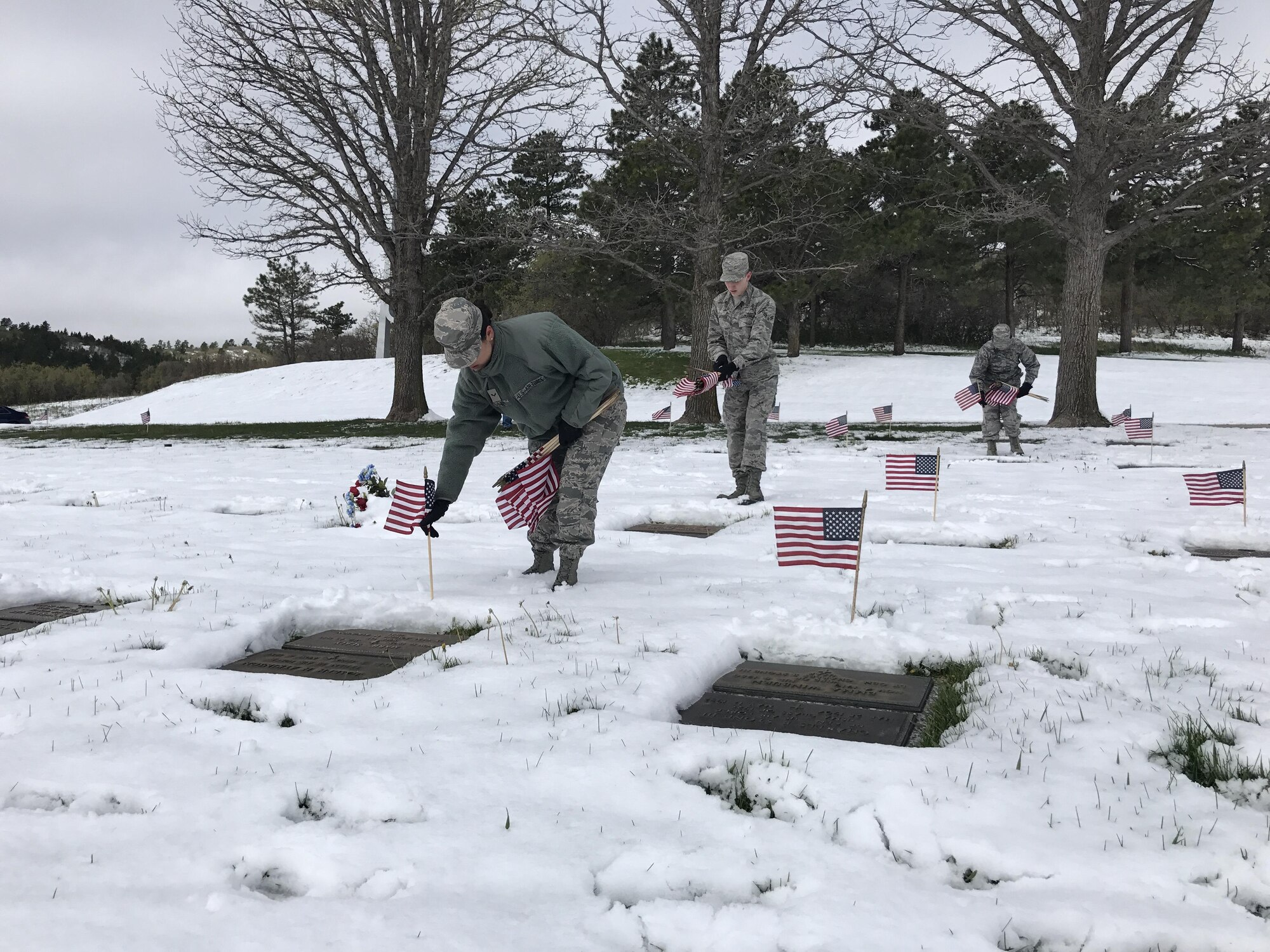 U.S. AIR FORCE ACADEMY, Colo. –Airmen place American flags on grave sites, May 19, 2017, at the U.S. Air Force Academy Cemetery, Colo. Approximately 40 Peterson Air Force, Colo., Airmen participate in the annual event to place over 1200 American flags in honor of Memorial Day. (Courtesy photo by Airman 1st Class Cynthia Munoz) 