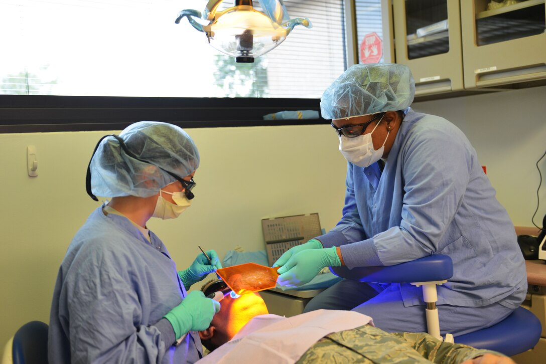 U.S. Air Force Maj. Christiane Trigueros, 20th Dental Squadron (DS) dentist, left, and Airman 1st Class Jeana Knappenberger, 20th DS dental assistant, use a dental resin curing light to harden a patient’s composite filling at Shaw Air Force Base, S.C., May 18, 2017. The 20th DS provides dental health services to all units on Shaw, helping to maintain the individual medical readiness of active-duty service members so they can be fit to fight anytime, anywhere. (U.S. Air Force photo by Airman 1st Class Destinee Sweeney)