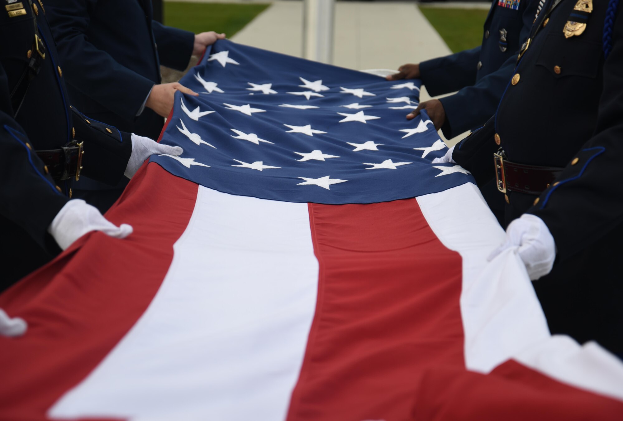 Airmen and law enforcement officers fold the flag during a memorial retreat ceremony during National Police Week May 15, 2017, at Fairchild Air Force Base, Washington. National Police Week pays special recognition to law enforcement officers who lost their lives in the line of duty for the safety and protection of others. (U.S. Air Force photo/Staff Sgt. Samantha Krolikowski) 