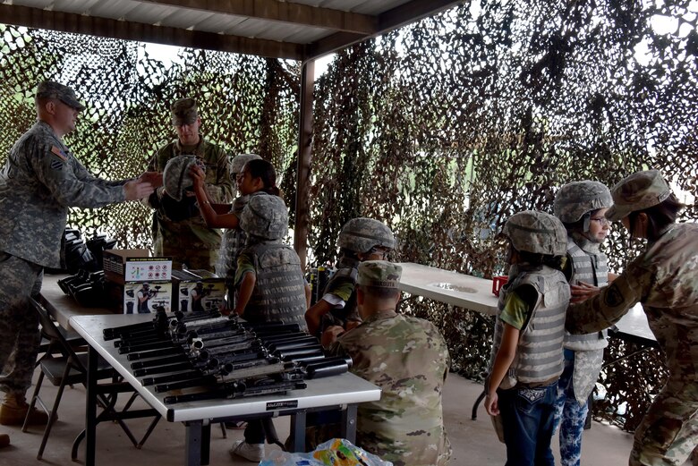 Children are fitted with battle gear for Operation: Kids Investigating Deployed Services at Camp Sentinel on Goodfellow Air Force Base, Texas, May 20, 2017. Operations K.I.D.S. gave children a mock deployment where they learned about weapons, patrolling and a joint-service environment. (U.S. Air Force photo by Staff Sgt. Joshua Edwards/Released)