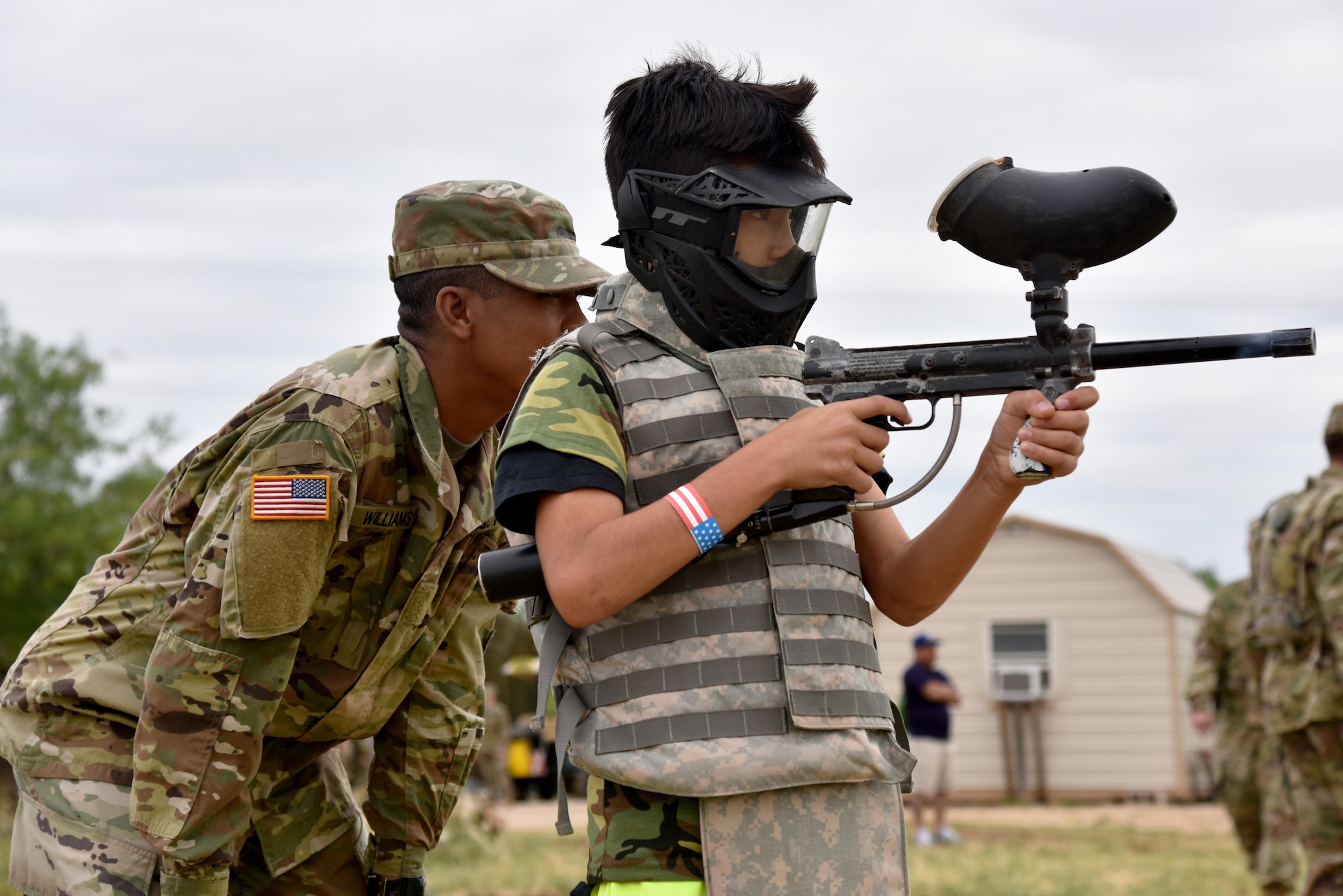 U.S. Army Pvt. Ricky Williams, 344th Military Intelligence Battalion student, teaches Dominick Cardens, Operation: Kids Investigating Deployed Services deployer, how to shoot a paintball gun during Operation: K.I.D.S. at Camp Sentinel on Goodfellow Air Force Base, Texas, May 20, 2017. Goodfellow’s Army and Marine Corps help provide the children with a joint-service mock deployment for Operation K.I.D.S. (U.S. Air Force photo by Staff Sgt. Joshua Edwards/Released)