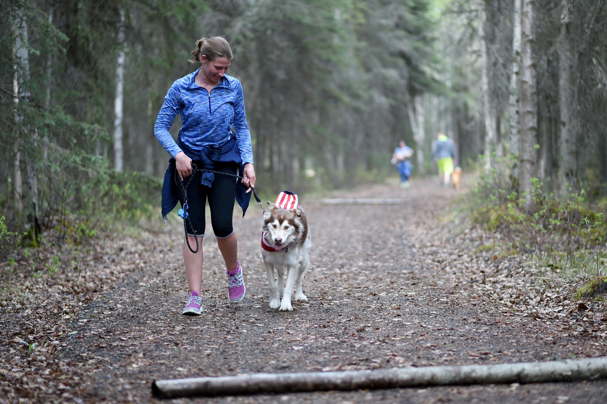 Ariana Corey and Bentley the dog stroll down the Eagleglen Fitness Park trail during the Pet Fun Run 5K, May 19, 2017. More than 40 athletes raced with their canine companions at the fun run. First, second and third place finishers received prizes, though all pets were given goodie bags.
