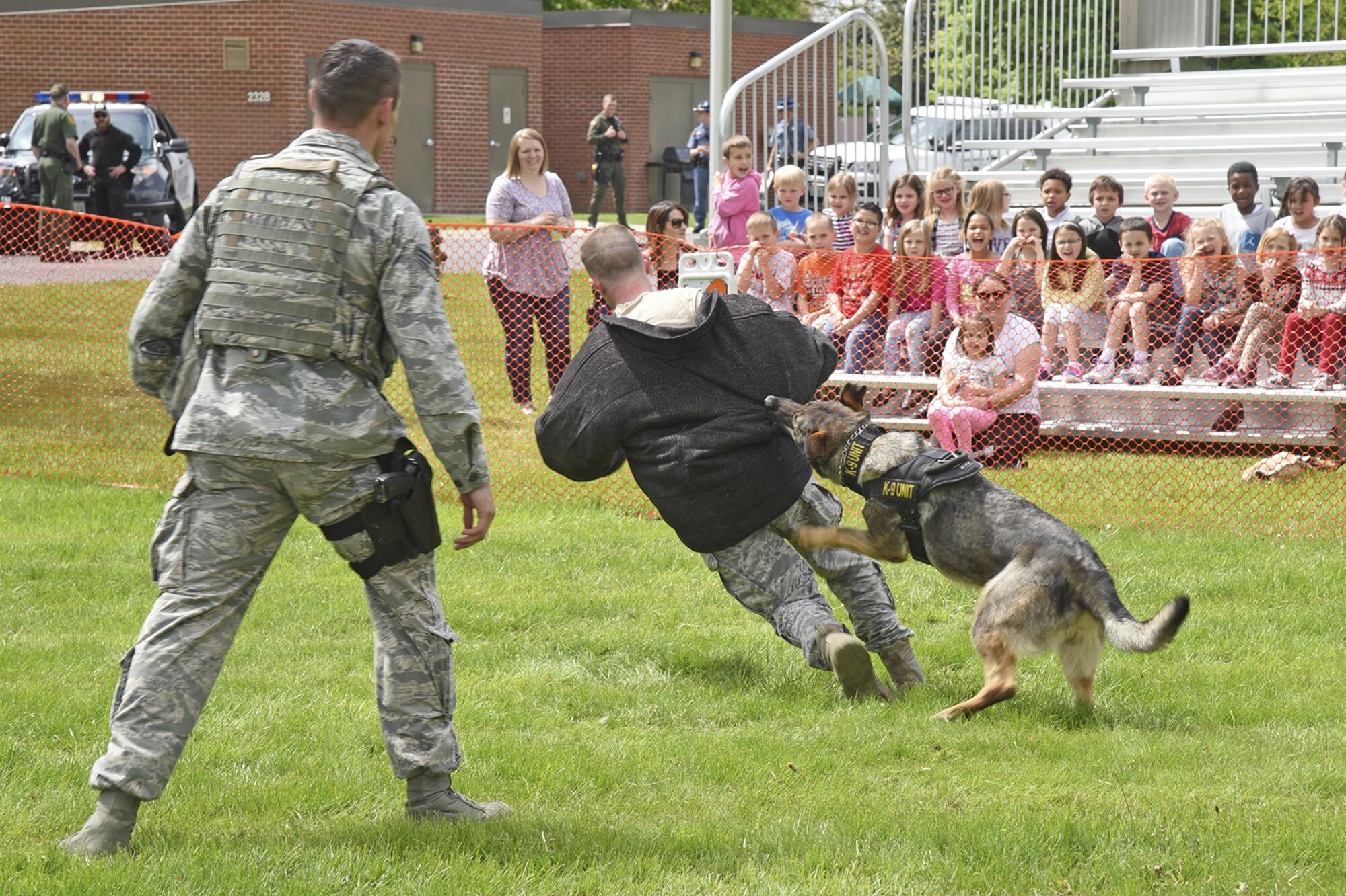 92nd Security Forces Squadron Airmen and Military Working Dog Brenda, demonstrate various apprehension techniques for Michael Anderson Elementary students during the kid-friendly Law Enforcement Exposition May 18, 2017, at Fairchild Air Force Base, Washington. The expo was part of a week-long remembrance of fallen law enforcement officers. (U.S. Air Force photo/Senior Airman Mackenzie Richardson)