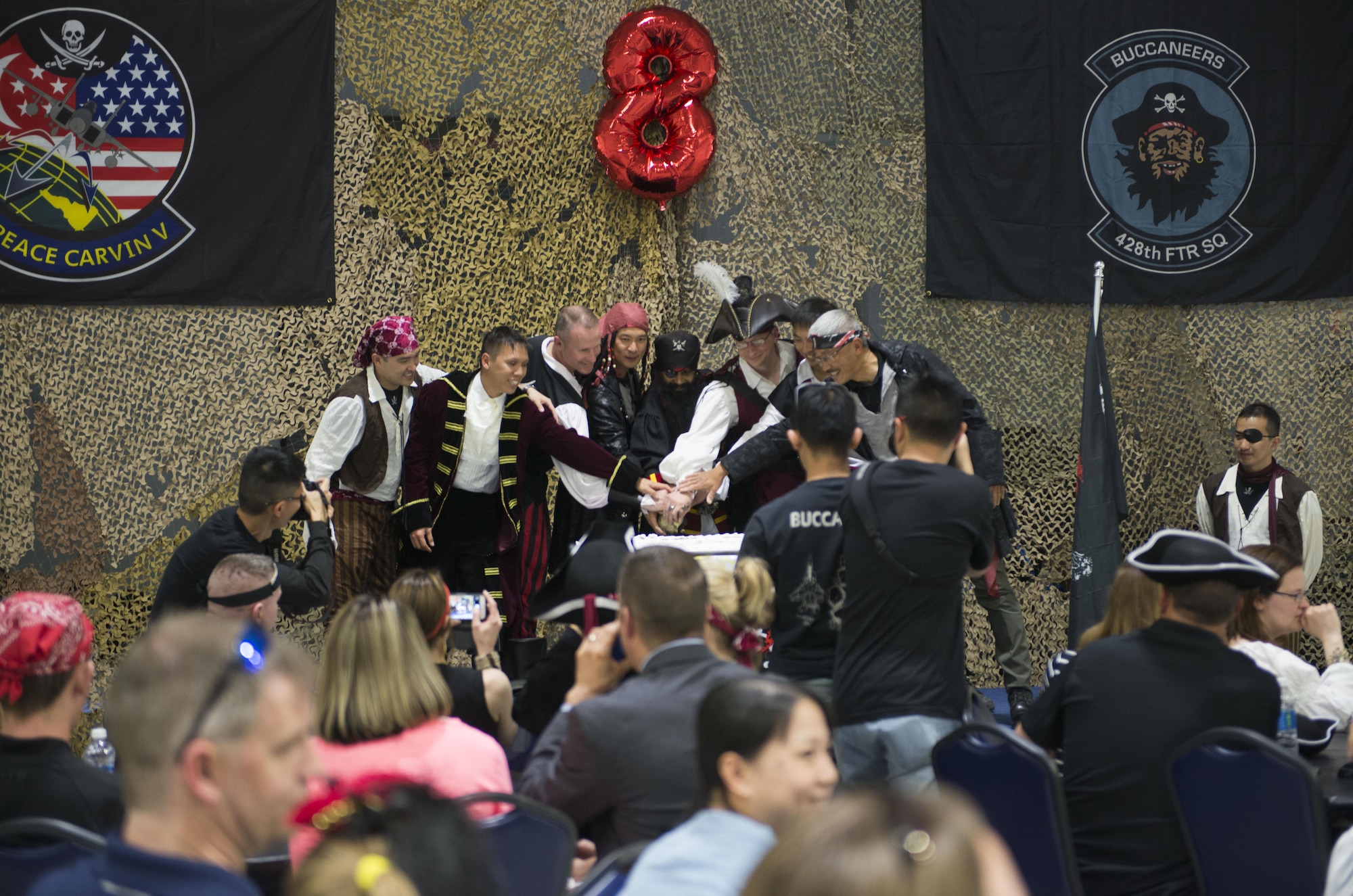 A cake is cut after the unveiling of a new 428th Fighter Squadron mascot, May 19th, 2017, at Mountain Home Air Force Base, Idaho. Each year, the Buccaneers introduce a new mascot as part of a pirate themed anneiverssary celebration. (U.S. Air Force photo by Senior Airman Malissa Lott/Released)