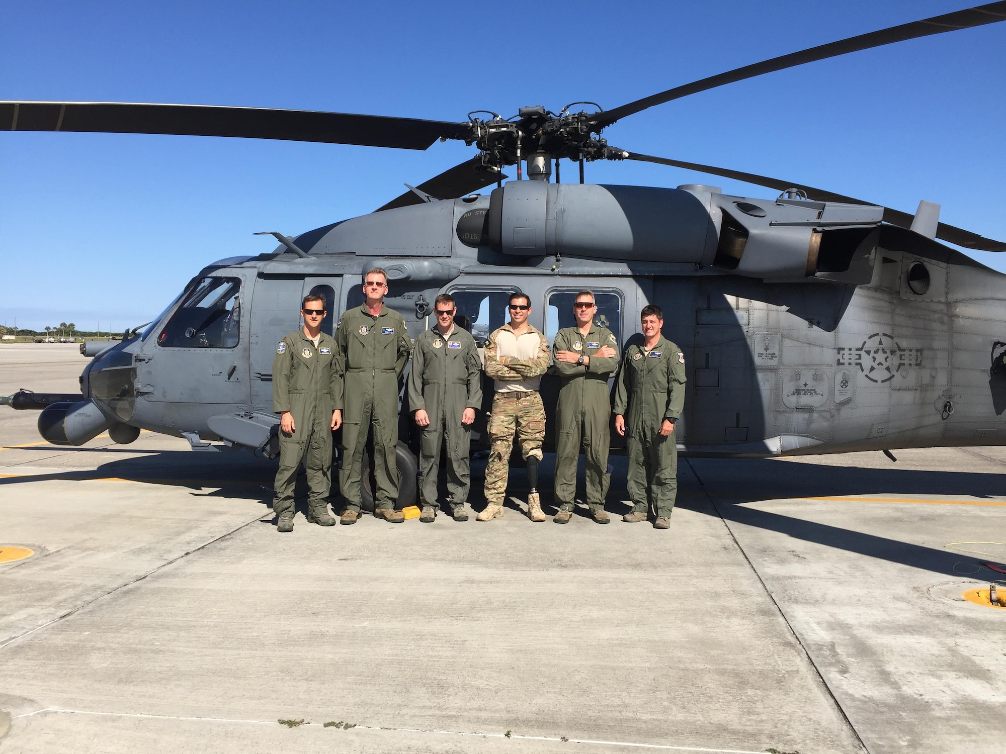 Staff Sgt. August O’Niell (center), pararescueman, and his Air Force Reserve Wingmen, an HH-60G Pave Hawk helicopter crew, reunited for the first time in June 2016 after the team embarked on a 2011 deployment to save lives when O’Niell was shot through both legs during a combat rescue mission in Afghanistan. O'Niell is the only single amputee pararescueman actively serving in the U.S. Air Force. (U.S. Air Force photo SrA Brandon Kalloo Sanes)