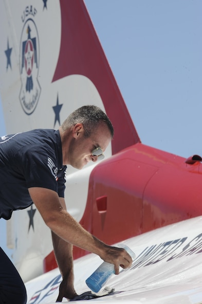 Staff Sgt. Jesse Barker, Thunderbird #1 crew chief, cleans his F-16 Fighting Falcon in preparation for a performance during Tinker Air Force Base's Star Spangled Salute air show May 20, 2017, Tinker Air Force Base, Oklahoma. Barker removed dirt and grime from the highly-polished jet with a wet rag. (U.S. Air Force photo/Greg L. Davis)
