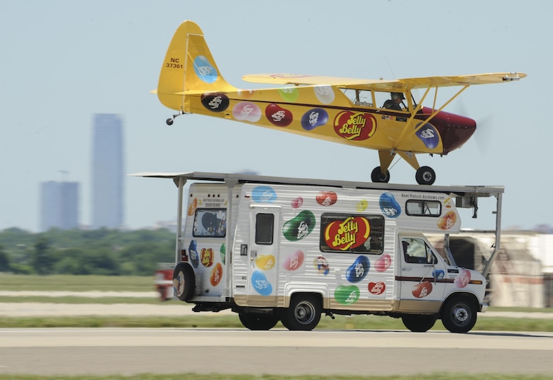 The Jelly Belly Interstate Cadet flown by Kent Pietsch lands on the roof of an RV barreling down the runway while the iconic skyline of Oklahoma City can be seen in the background during Tinker Air Force Base's Star Spangled Salute air show May 21, 2017, Tinker Air Force Base, Oklahoma. The air show had record attendance of over 100,000+ people due to clear skies, mild temperatures and a great line-up of military and civilian acts. (U.S. Air Force photo/Greg L. Davis)