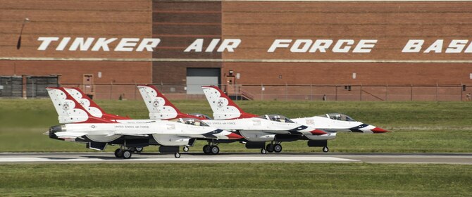 Four Thunderbird F-16s accelerate down the runway with the Tinker Air Force Base signage on building 3001 visible above them to begin their display during Tinker Air Force Base's Star Spangled Salute air show May 21, 2017, Tinker Air Force Base, Oklahoma. The Thunderbirds performed to record crowds during the weekend as the stars of the show. (U.S. Air Force photo/Greg L. Davis)