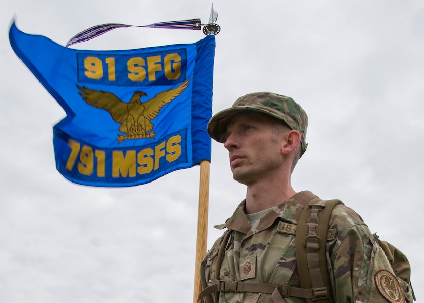 Master Sgt. Christopher Davis, 791st Missile Security Forces Squadron first sergeant, carries the guidon during the National Police Week 5K Remembrance Ruck March at Minot Air Force Base, N.D., May 16, 2017. During the week, Minot AFB security forces personnel planned a parade, weapon and vehicle display, 5K Remembrance Ruck March, 5K Memorial Run, and a retreat ceremony to end the week. (U.S. Air Force photo/Airman 1st Class Alyssa M. Akers)