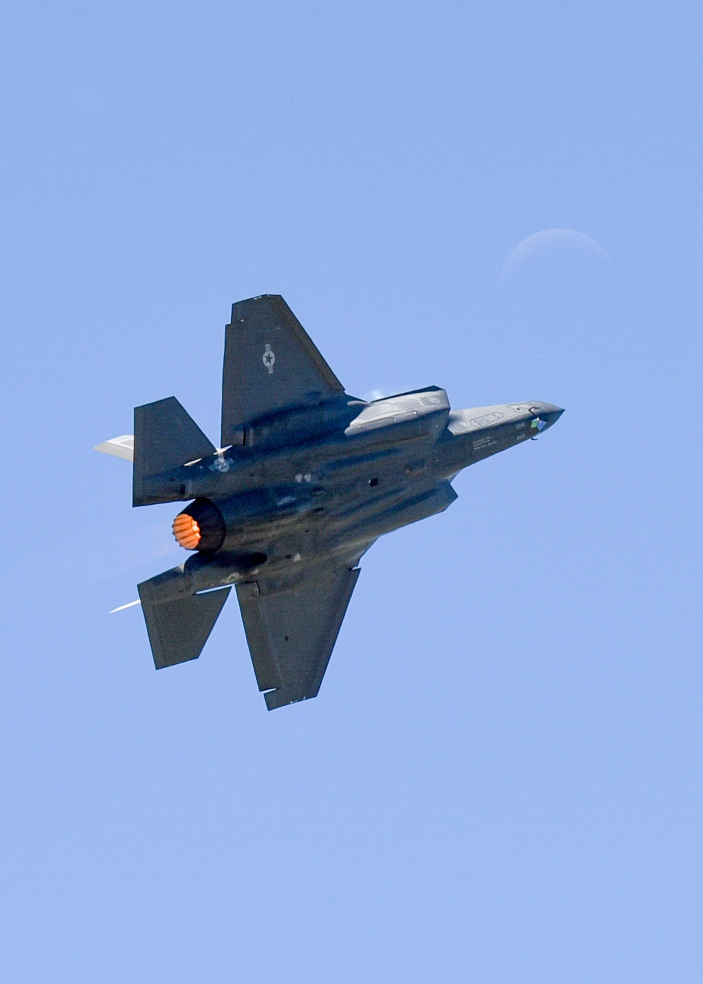 An F-35A Lightning II takes its show to the moon during the 2017 Star Spangled Salute air show at Tinker AFB May 21.  The joint strike fighter was one of more than 50 statics and aerial acts on display for the airshow as record crowds helped Tinker celebrate its 75th anniversary as well as the Air Force 70th birthday.  (U.S. Air Force photo/Mark Hybers)