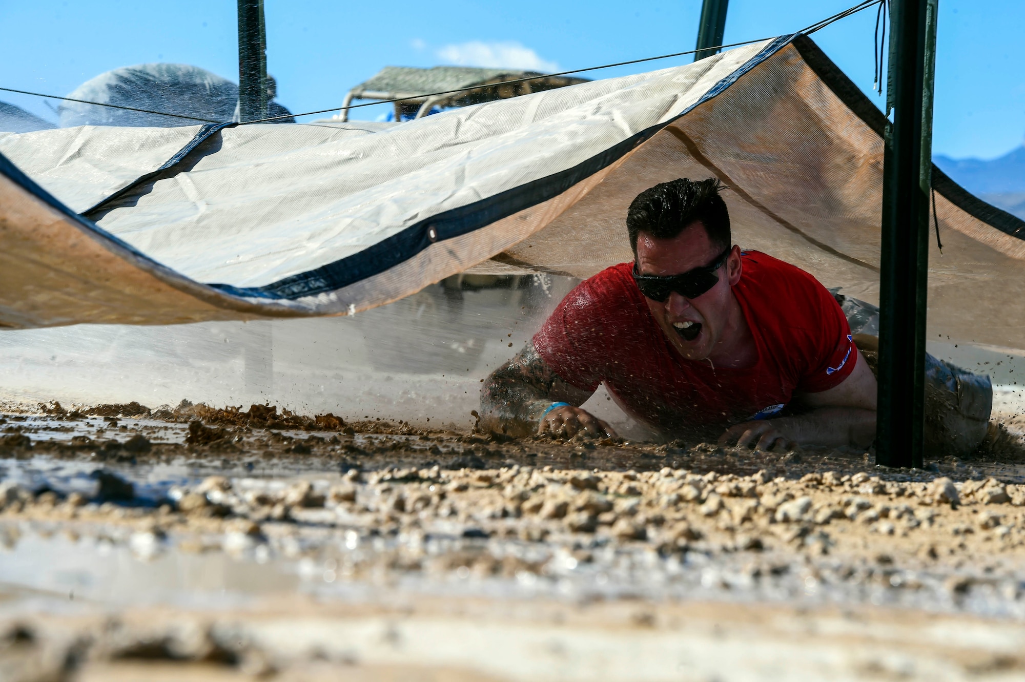 Senior Airman Brian, 799th Security Forces Squadron Military Working Dog Handler performs the low crawl during the Life of a Warrior Challenge May 18, 2016 at Creech Air Force Base, Nev. The SFS Airmen, local highway patrol officers and Las Vegas Police Department gathered together during National Police Week at Creech AFB for a law enforcement fitness challenge honoring those who have served in law enforcement. (U.S. Air Force photo by Airman 1st Class Adarius Petty)