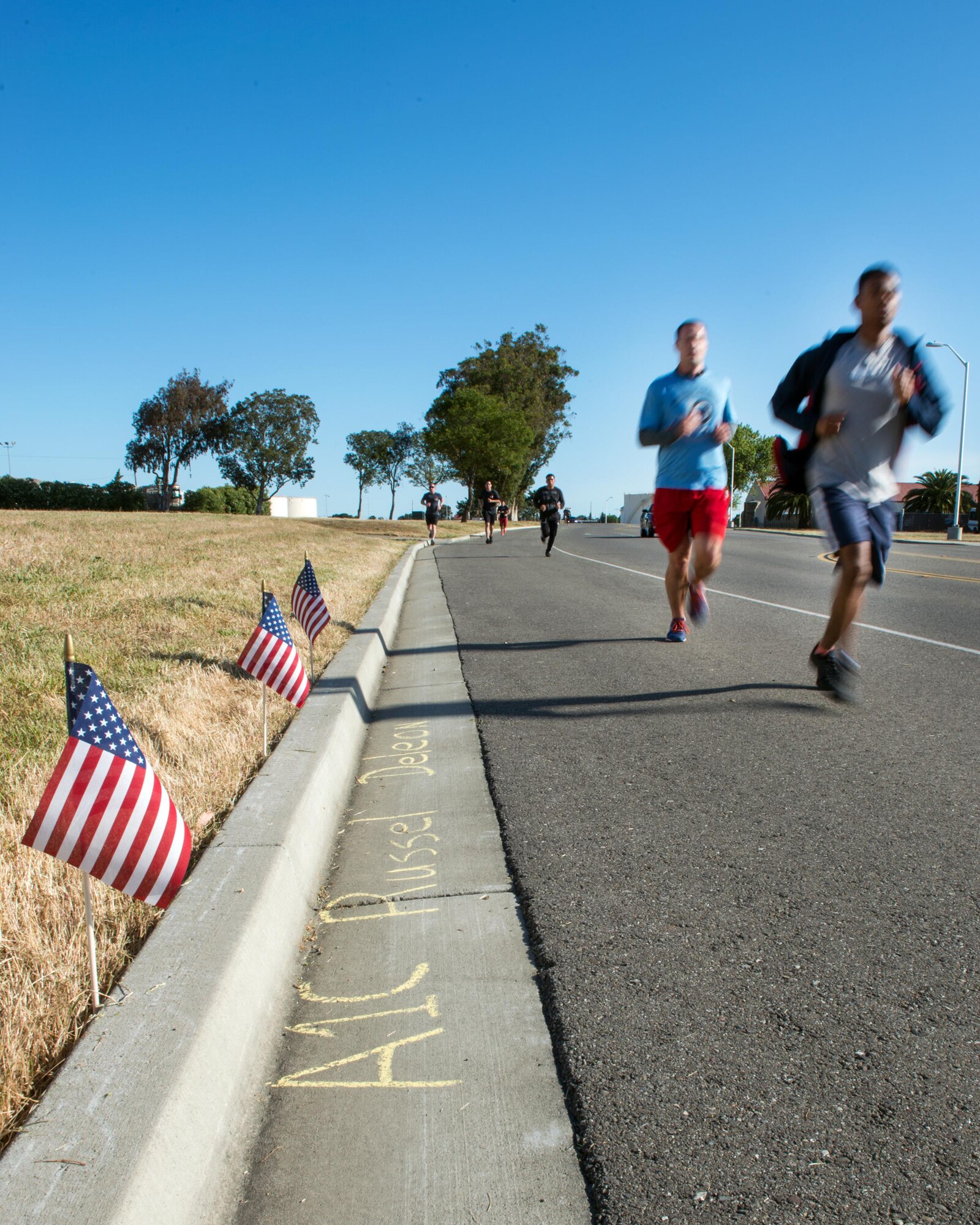 Members from the 60th, 349th, and 821st Aerial Port Squadrons, participate in the annual 5K Port Dawg Memorial Run at Travis Air Force Base, Calif., May 17, 2017. The run honors the memories of four fallen heroes, Master Sgt. William Davis, Master Sgt. Kelly Bartholomew, Staff Sgt. Jonathan Turner, and Airman 1st Class Russel Deleon. (U.S. Air Force photo by Louis Briscese)