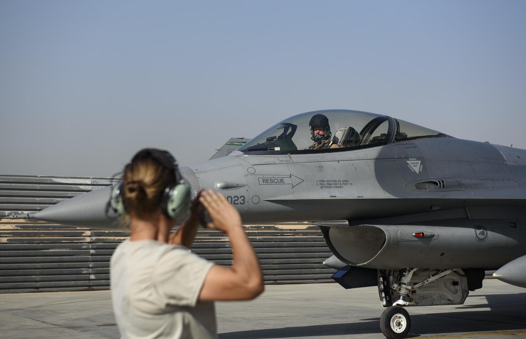 Senior Airman Heather Deines, 455th Expeditionary Aircraft Maintenance Squadron, marshals an F-16 Fighting Falcon, piloted by Brig. Gen. Jim Sears, at Bagram Airfield, Afghanistan, May 22, 2017. Sears, commander of the 455th Air Expeditionary Wing, conducted his final flight out of Bagram Airfield. (U.S. Air Force photo by Staff Sgt. Benjamin Gonsier)