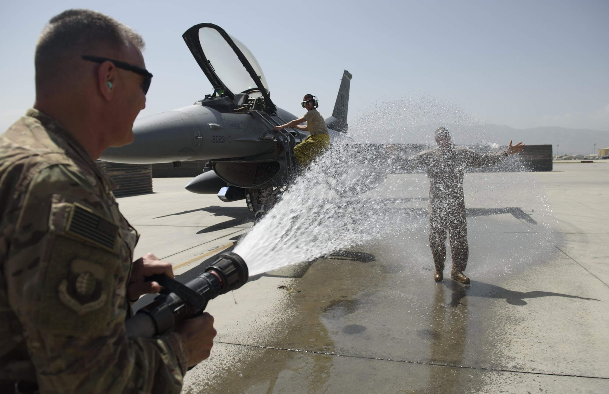 Chief Master Sgt. Peter Speen, command chief of the 455th Air Expeditionary Wing, hoses down Brig. Gen. Jim Sears at Bagram Airfield, Afghanistan, May 22, 2017. Sears, commander of the 455th AEW, conducted his fini flight out of Bagram Airfield. The fini flight is a time-honored military aviation tradition marking the last flight of a commander's tour. (U.S. Air Force photo by Staff Sgt. Benjamin Gonsier)