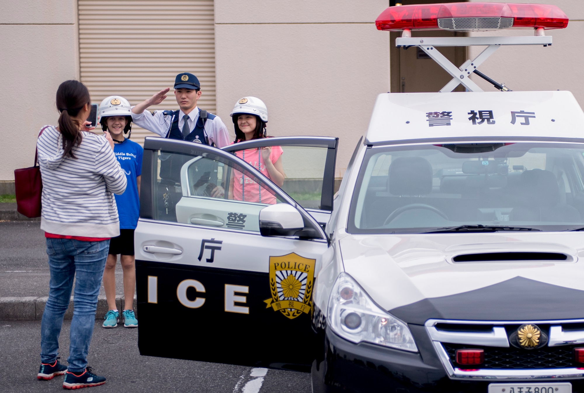 A family poses for photo with a Japanese police officer during a Police Week event, May 17, 2017, at Yokota Air Base, Japan. The event included various static displays from the Tokyo Police Department, Japan Air Self Defense Force, 374th Security Forces Squadron and U.S. Office of Special Investigations. (U.S. Air Force photo by Airman 1st Class Donald Hudson)