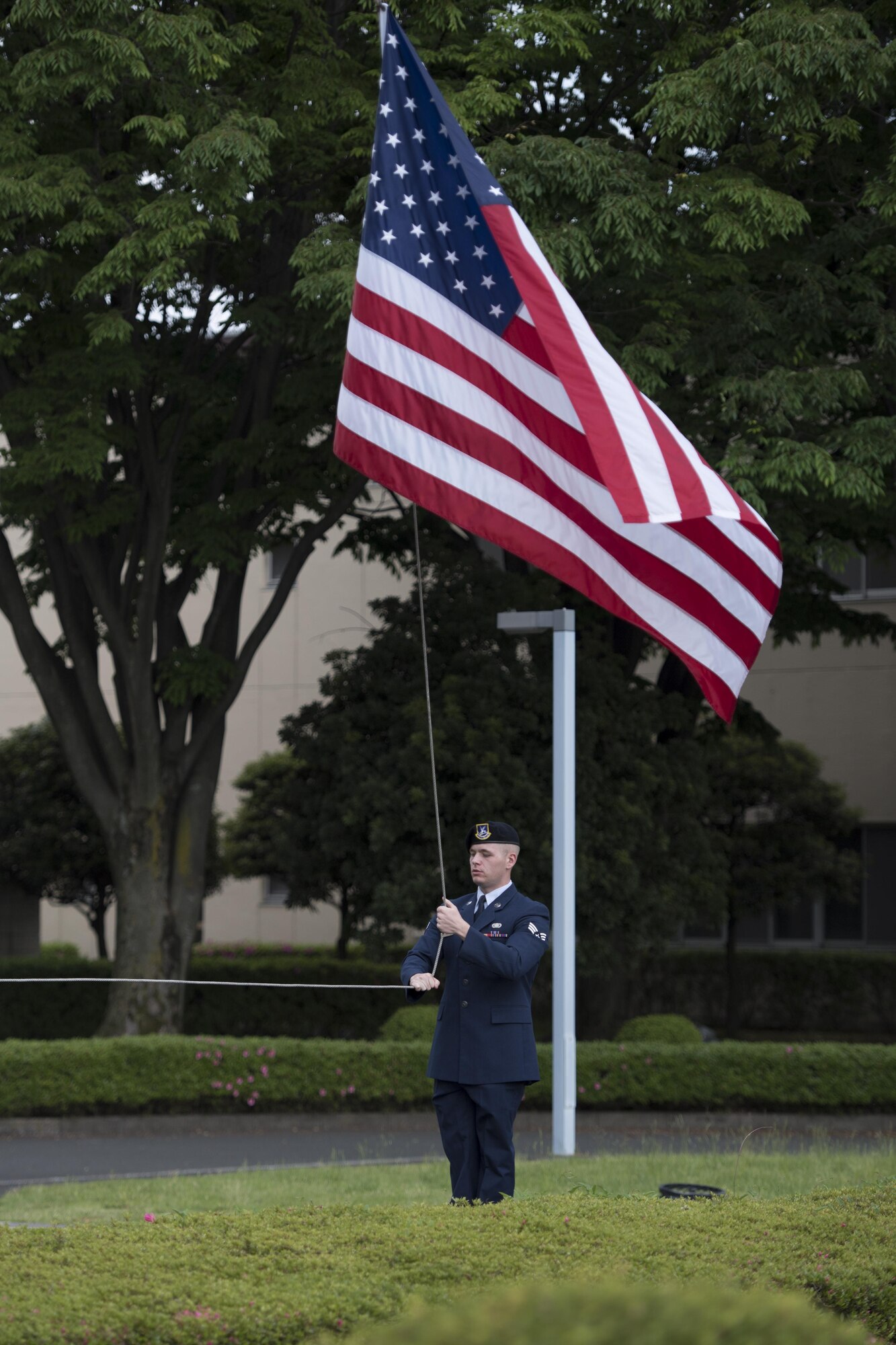 Senior Airman Trent Lamb, 374th Security Forces Squadron alarm monitor, lowers the flag during a memorial retreat ceremony for fallen law enforcement members, May 18, 2017, at Yokota Air Base, Japan. The ceremonial lowering and folding of the flag was done by members of the 374 SFS who are also part of Yokota’s Honor Guard. (U.S. Air Force photo by Airman 1st Class Donald Hudson)