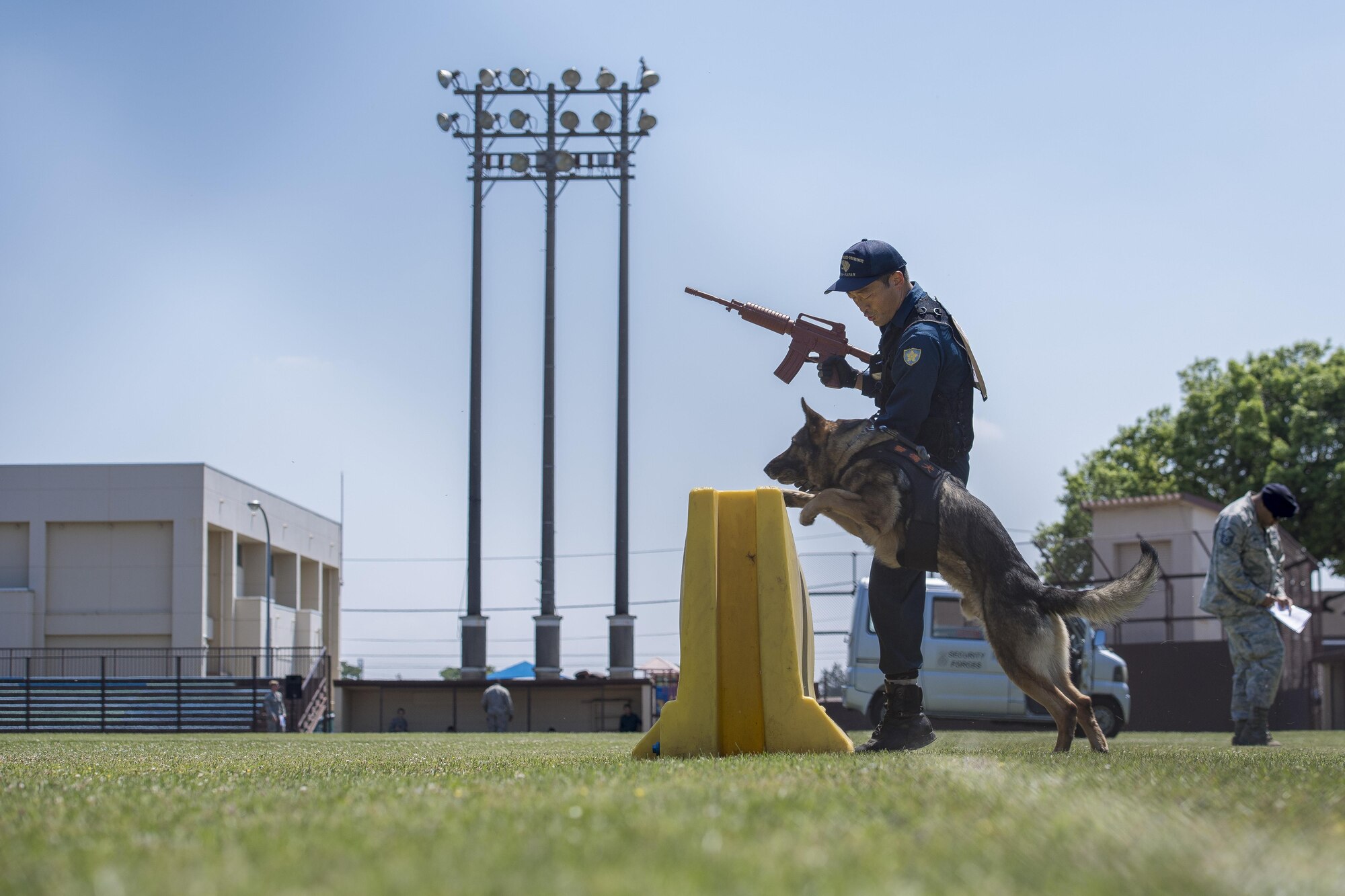 A Tokyo Metropolitan Police Department K-9 unit jumps a barricade during a Police Week K-9 Unit tactical obstacle course competition, May 19, 2017, at Yokota Air Base, Japan. The competition included members of the Tokyo Metropolitan Police Department, 374th Security Forces Squadron and U.S. Army competitors. (U.S. Air Force photo by Airman 1st Class Donald Hudson)