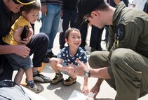 U.S. Air Force Capt. Dakota Newton, a Pacific Air Forces F-16 Demonstration Team safety observer, shares a thumbs up with a young boy during the Hofu Air Festival at Hofu-kita Air Base, Japan, May 21, 2017. The interaction with community is one aspect of the teams overall mission, the other being a display of the F-16 Fighting Falcons air power. (U.S. Air Force photo by Staff Sgt. Melanie Hutto)
