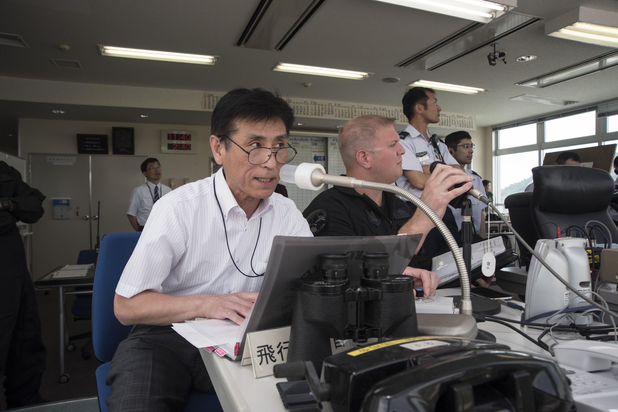 Hiromichi Nara, left, the Pacific Air Forces F-16 Demonstration Team translator and liaison, and U.S. Air Force Tech. Sgt. Tristan Berger, the PACAF F-16 Demonstration Team aerospace propulsion craftsman and narrator, announce the different maneuvers the demo pilot performs  during the Hofu Air Festival, May 21, 2017 at Hofu-kita Air Base, Japan. Nara joined the demo team at its inception almost 20 years ago. Berger became a team member one year ago. The primary objective of the team is to showcase the F-16 Fighting Falcon’s capabilities to countries that fall within PACAF’s area of responsibility. (U.S. Air Force photo by Staff Sgt. Melanie Hutto)