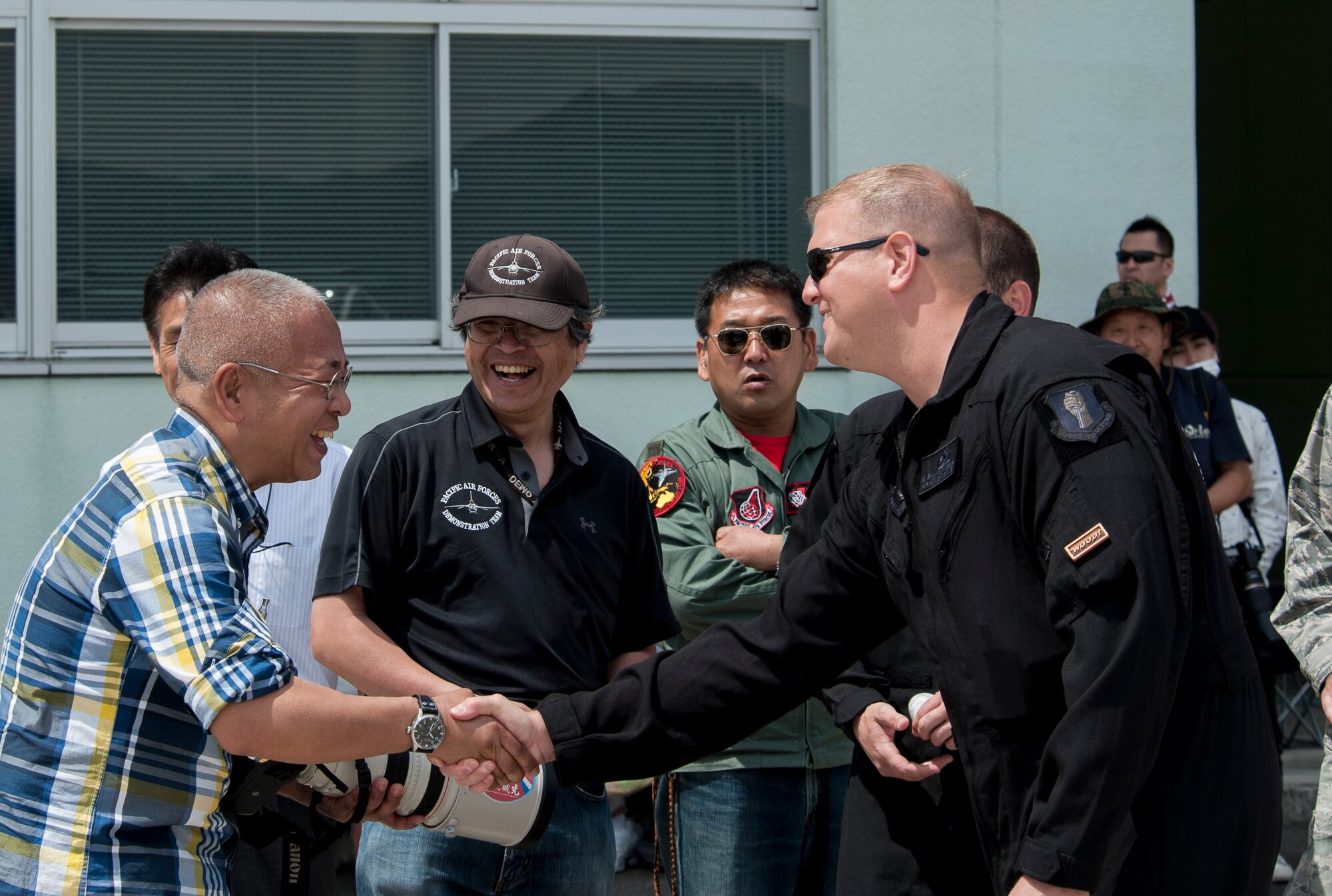 U.S. Air Force Tech. Sgt. Tristan Berger, the Pacific Air Forces F-16 Demonstration Team aerospace propulsion craftsman and narrator, shakes hands with a Japanese local during the Hofu Air Festival, at Hofu-kita Air Base, Japan, May 21, 2017. Making personal contact with local nationals on and off the flight line showcases the U.S. and Japan bilateral relationship is more than just on a military basis. Besides the show schedule, team members must be ready to deploy in support of the 35th Fighter Wing's wartime mission while handling their day-to-day jobs within the squadron. (U.S. Air Force photo by Staff Sgt. Melanie Hutto)