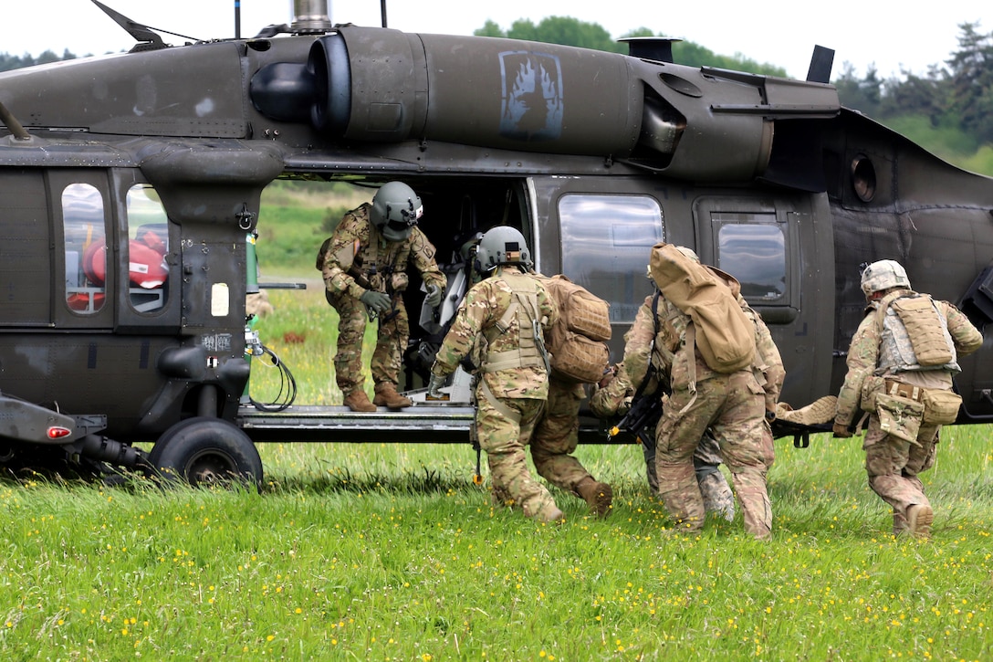 Soldiers load a mock casualty onto a UH-60 Black Hawk helicopter during medical evacuation training in Grafenwoehr, Germany, May 22, 2017. Army photo by Staff Sgt. Kathleen V. Polanco 