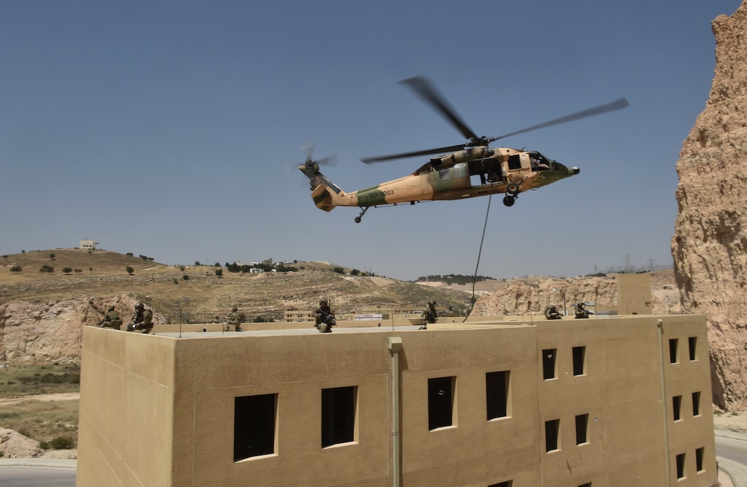 Italian special operations forces, U.S. Air Force Special Tactics and members of the Jordanian Armed Forces Special Task Force fast rope from a Royal Jordanian Air Force UH-60L Blackhawk helicopter onto a three-story building during Exercise Eager Lion May 11, 2017, at King Abdullah II Special Operations Training Center. Eager Lion is an annual U.S. Central Command exercise in Jordan designed to strengthen military-to-military relationships between the U.S., Jordan and other international partners. This year's iteration is comprised of about 7,200 military personnel from more than 20 nations that will respond to scenarios involving border security, command and control, cyber defense and battlespace management. (U.S. Air Force photo by Senior Airman Ryan Conroy)