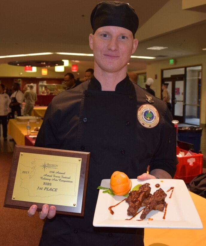 Navy Petty Officer 2nd Class Christopher Wojcik of Naval Hospital Bremerton, Wash., poses for a photo with a plate of his award-winning barbecue ribs, May 6, 2017. Navy photo by Douglas H. Stutz