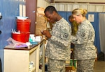 Spc. Akeem M. Oliver and Cpt. Tanya L. West, both with the Mississippi Medical Detachment, Mississippi Army National Guard, prepare medical supplies at the detachment’s aid station 21 May, 2017, at the National Training Center, Fort Irwin, Calif. The medical detachment is providing care for the service members from approximately 40 units from around the country taking part in the 155th Armored Brigade Combat Team’s training rotation at NTC. 