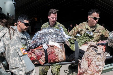 Cpl. Sean Gauthier, a medic for 5 Field Ambulance from Quebec, Canada, gets a first glimpse of a simulated traumatic injury being carried by US medical personnel during exercise Maple Resolve.  The exercise is Canada's premiere brigade-level validation exercise used to sharpen the war-fighting skills and improve readiness for US and Canadian forces.