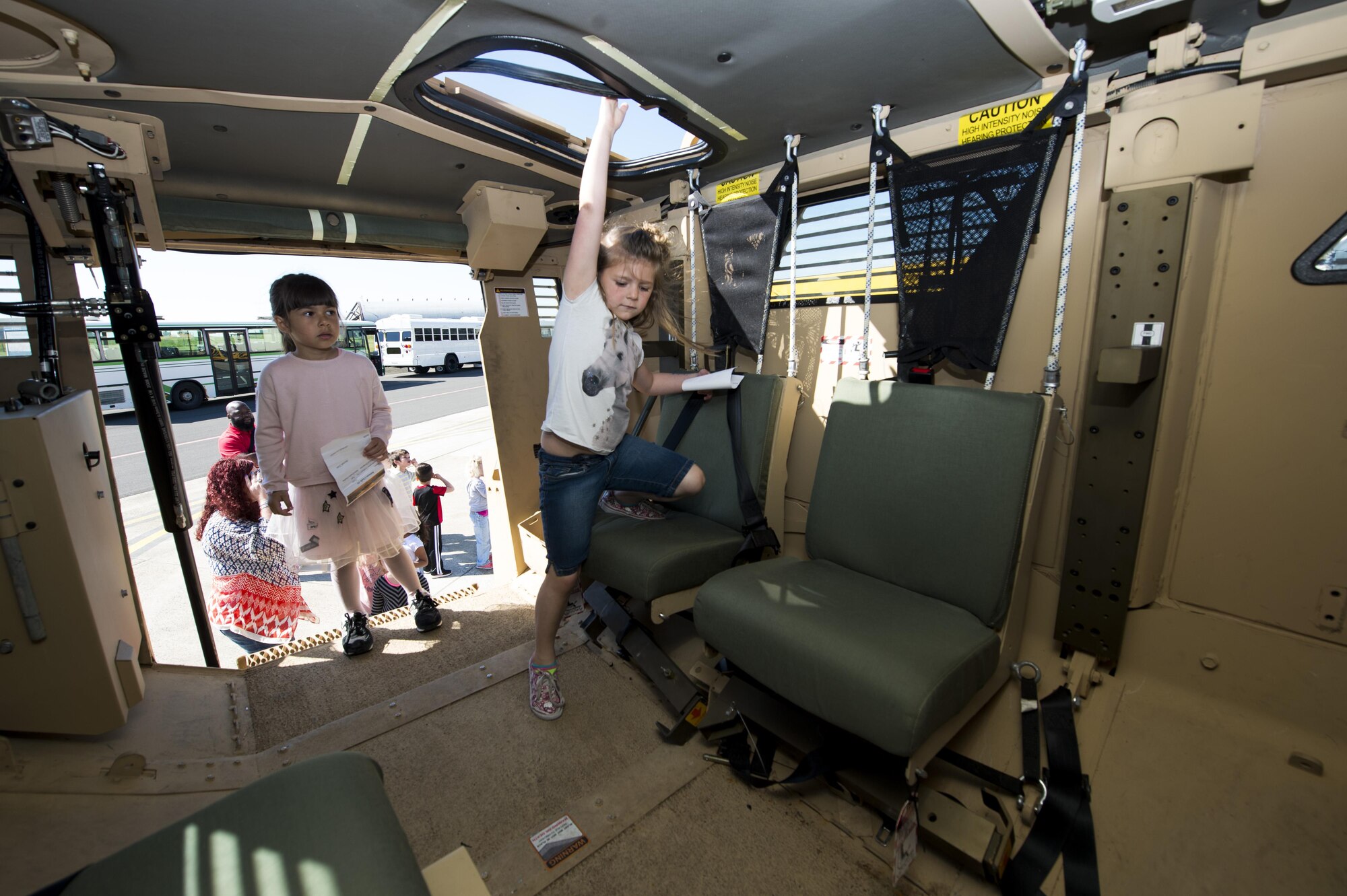 Students from Spangdahlem Elementary School explore an armored vehicle during Children’s Deployment Days at Spangdahlem Air Base, Germany, May 22, 2017. The deployment line featured several sections to inform children about deploying, including a pre-deployment brief, a look at deployment gear, mock immunizations, static vehicle displays and a tour of a C-17 Globemaster III aircraft. (U.S. Air Force photo by Airman 1st Class Preston Cherry)