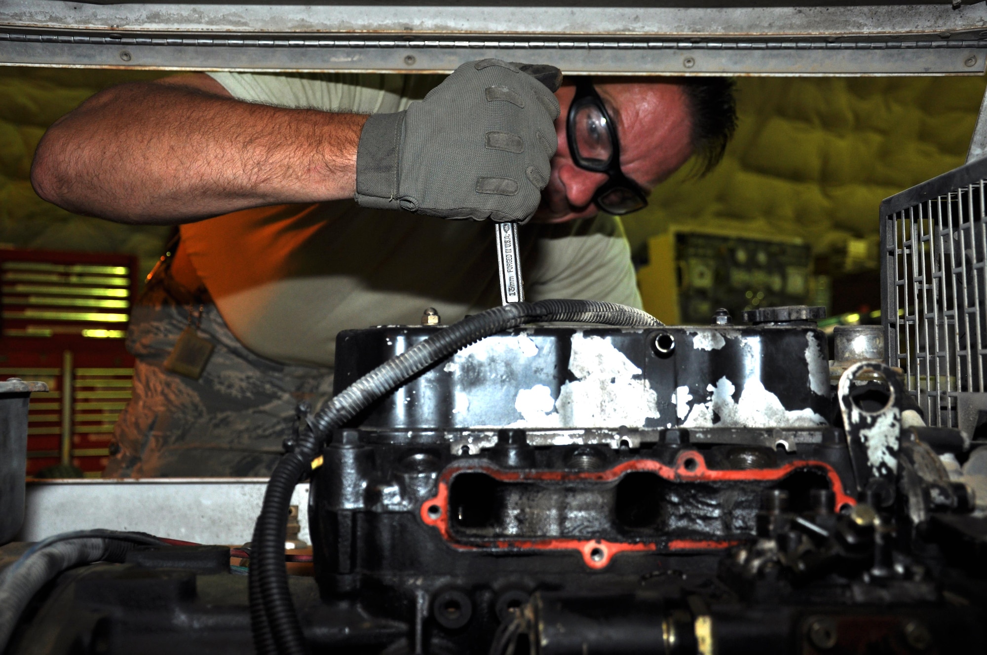Staff Sergeant Jordan LeMay, the 386th Expeditionary Civil Engineer Squadron NCO in charge of light carts, loosens a rusted exhaust manifold bolt during a light cart teardown at the 386 ECES Power Production facility Wednesday, May 17, 2017.  This cart was being converted to run off of the base power grid. (U.S. Air Force photo/Master Sgt. Eric Sharman)