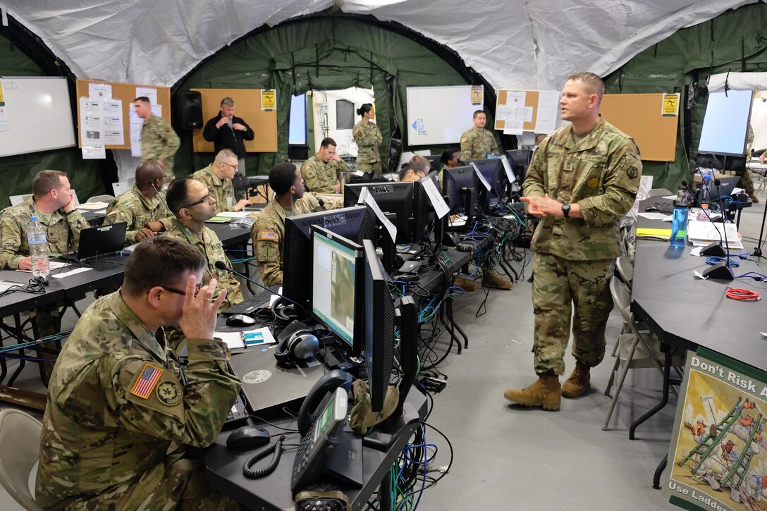 Master Sgt. Pierre Brudnicki, right, speaks to the battle staff Friday, May 12, 2017 during the 7th Mission Support Command's Command Post Exercise at Panzer Kaserne in Kaiserslautern. 