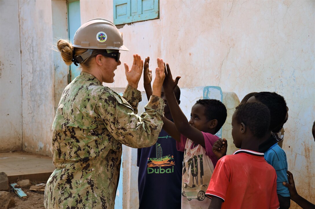 U.S. Navy Petty Officer 3rd Class Lacy P’Pool, Naval Mobile Construction Battalion ONE member of Combined Joint Task Force-Horn of Africa, plays a hand-clapping game with a student while on break near the Seabees job site in the Arta Region, Djibouti, May 18, 2017. The nearly 10-person team is working to build both a medical clinic and bond with the regional people. (Photo by U.S. Air National Guard photo by Tech. Sgt. Andria Allmond)