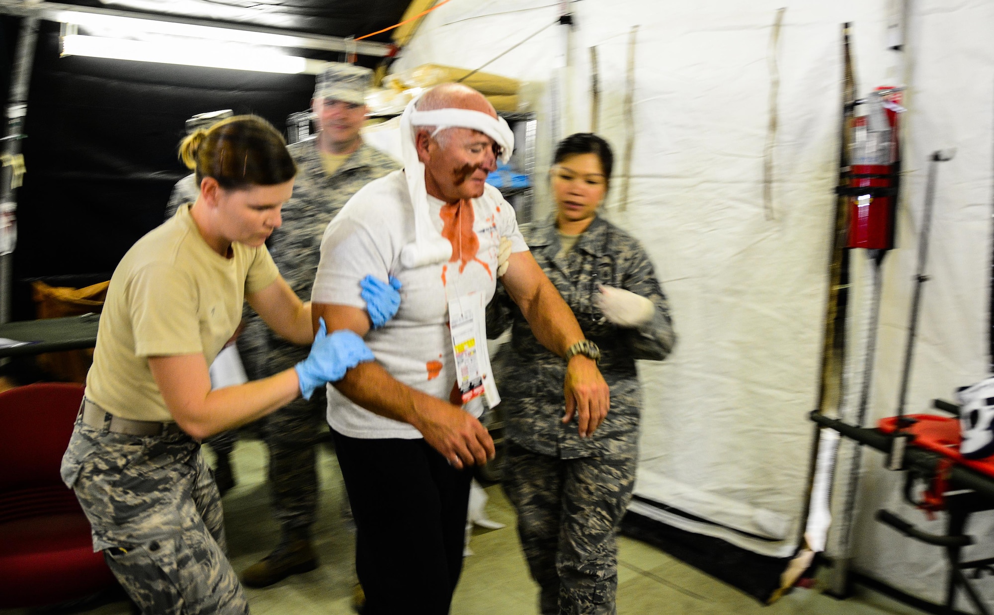 Staff Sgt. Cari Snyder and Master Sgt. Breezyjune Guerrero, 349th Aeromedical Squadron medical techinicians, guide a moulaged Staff Sgt. Rickey Popplewell, 129th Medical Group medical technician, to a chair during a mass casualty exercise at Travis Air Force Base, Calif., on May 19, 2017. The 349th MDG conducted a week-long training session for medical Airmen that culminated in a mass casulaty training scenario. (U.S. Air Force photo/Staff Sgt. Daniel Phelps)