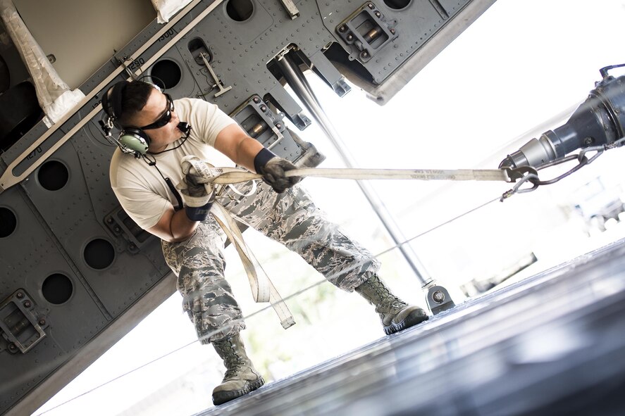 An Airman from the 41st Helicopter Maintenance Unit guides a winch cable pulling an HH-60G Pave Hawk into a C-17 Globemaster III, May, 15, 2017, at Moody Air Force Base, Ga.  Loading the helicopter for transport was the first step in a rapid-rescue exercise conducted at Langley AFB, Va., which was designed to test the maintainer’s and aircrew’s ability to quickly set up and conduct rescue operations away from their home station. (U.S. Air Force photo by Staff Sgt. Ryan Callaghan)