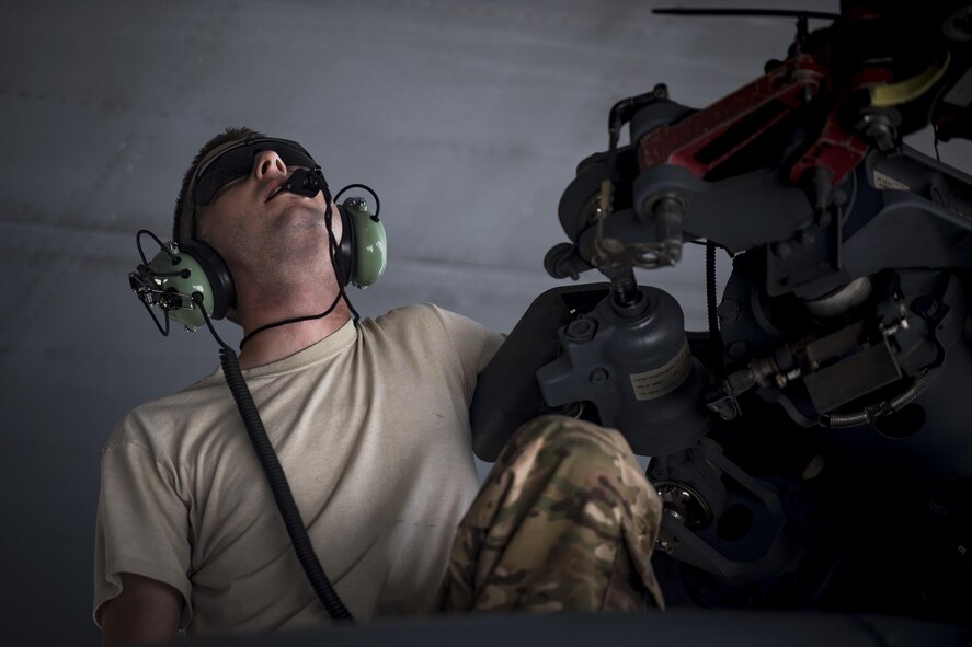 An Airman from the 41st Helicopter Maintenance uUit sits on top of an HH-60G Pave Hawk May 15, 2017, at Moody Air Force Base, Ga. While loading the helicopter into a large transport aircraft, an airman will sit near the rotor and on the tail to ensure there is no contact between aircraft. (U.S. Air Force photo by Staff Sgt. Ryan Callaghan)